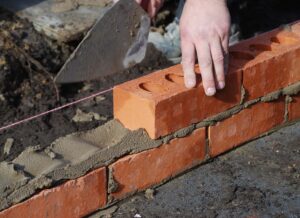bricklayer laying bricks for wall